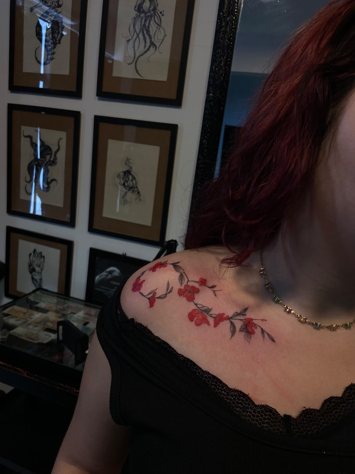 Tatuagem floral com flores vermelhas no ombro